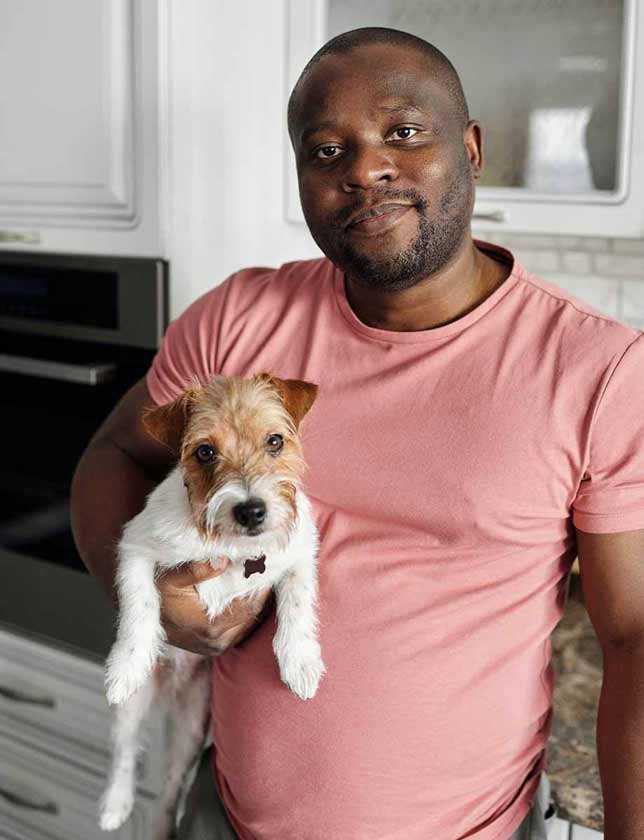 Man carrying his terrier dog under one arm