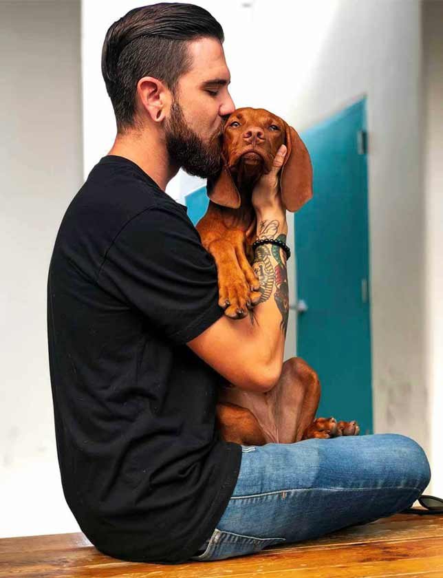 Man kissing puppy on the head